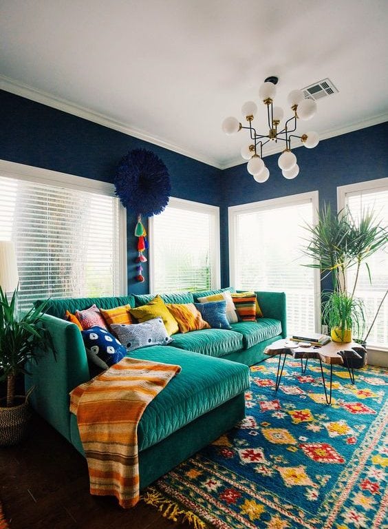 Teal sectional couch near blinded windows
