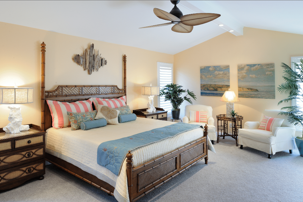 White and blue bed beside turned on table lamp inside room