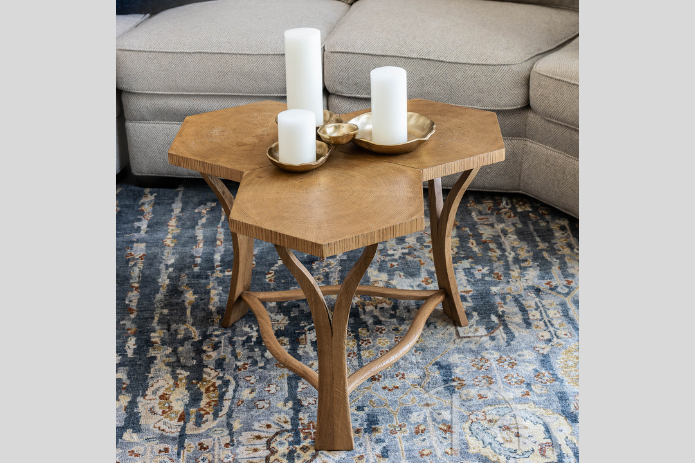 quirky wooden coffee table and neutral gray sofa on blue and brown patterned rug