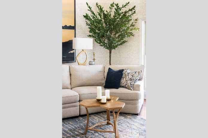 curved gray sofa and tall faux tree in transitional hearth room in Frontenac Missouri